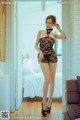 A woman in a black lingerie posing for the camera.