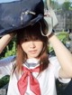 A woman in a sailor outfit holding a hat over her head.