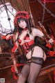 A woman in a red and black lingerie sitting on a chair.