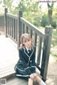 A woman in a school uniform sitting on a wooden bench.