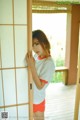 A young woman standing in front of a sliding door.