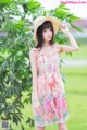 A woman in a dress and hat posing for a picture.