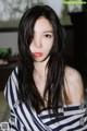A woman with long black hair wearing a striped shirt.