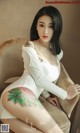 A woman sitting on a chair with a tattoo on her leg.