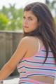 A young woman in a striped tank top posing for a picture.