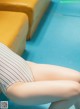 A woman in a striped bathing suit sitting on a yellow chair.