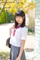 A young woman in a school uniform posing for a picture.