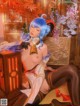 A woman with blue hair is sitting on a chair.