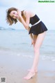 A woman in a black and white bathing suit on the beach.