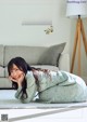 A woman laying on the floor in front of a couch.