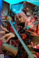 A woman with pink hair holding two swords in her hands.