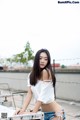 A woman in a white shirt and denim shorts posing for a picture.