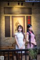 Two women standing next to each other in front of a building.