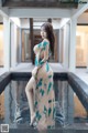 A woman in a long dress standing in a pool.