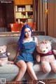 A woman sitting on a couch with two teddy bears.