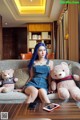 A woman sitting on a couch with two teddy bears.