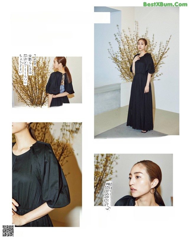 A woman in a black dress standing in front of a plant.